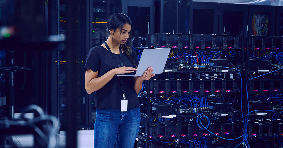 woman looking at computer in server room